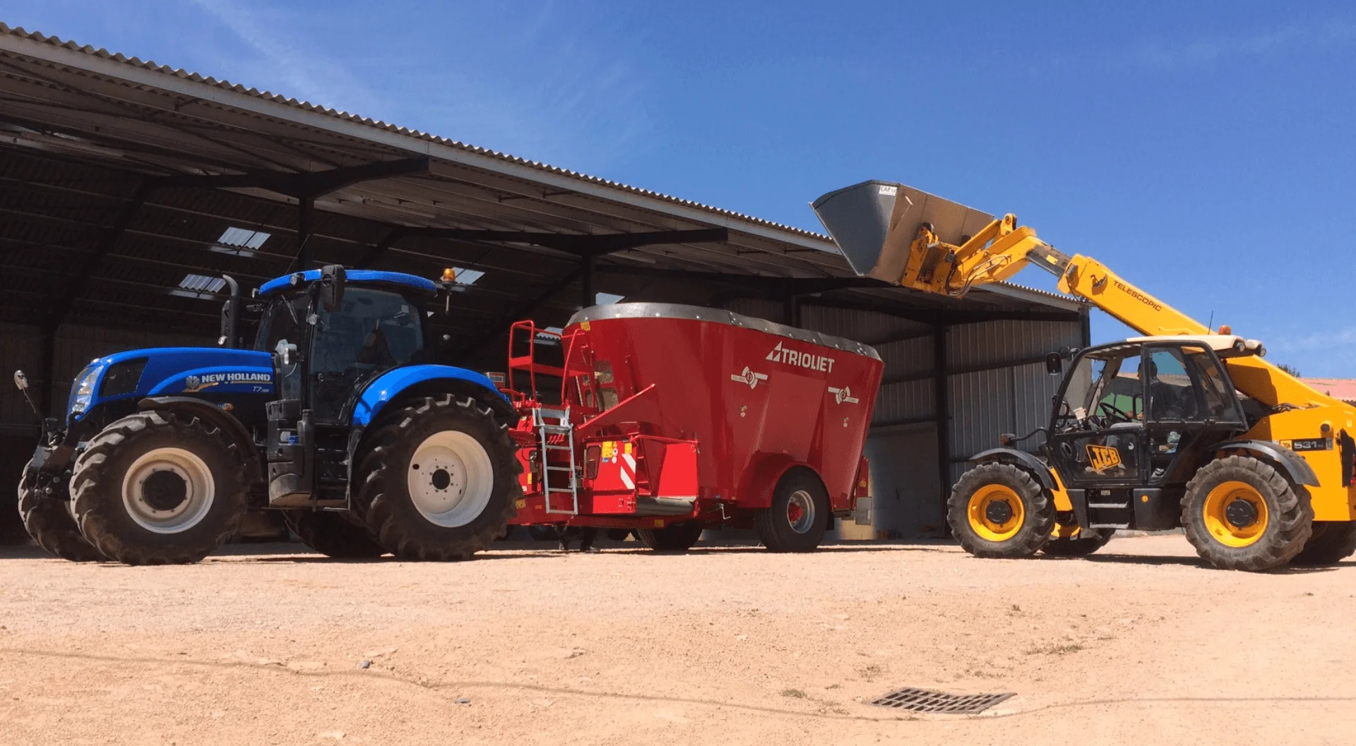 Triolet mixer attached to a New Holland tractor with a wheel loader